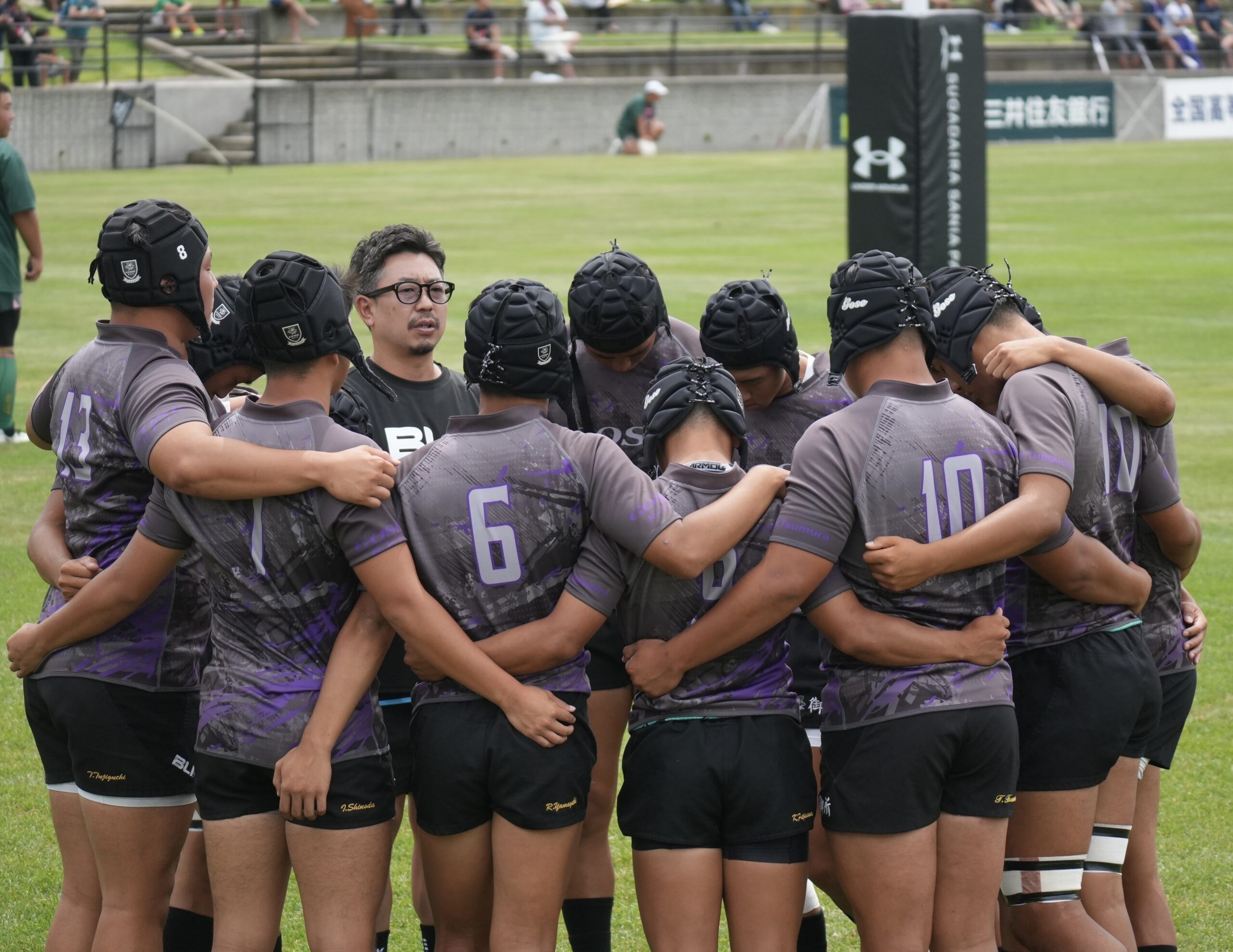 ラグビーコーチが選手とミーティングを行なっている様子